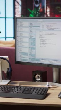 Geliştirme aracı uygulamasında PC çalışma istasyonu ekranında yazılan kodların dikey video hatları. Oturma odasındaki bilgisayar ekranında görüntülenen yazılım programlama dili hata ayıklama işlemi