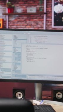 Geliştirme aracı uygulamasında PC çalışma istasyonu ekranında yazılan kodların dikey video hatları. Oturma odasındaki bilgisayar ekranında görüntülenen yazılım programlama dili hata ayıklama işlemi