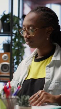 Evrakları internet şirket dosyalarıyla karşılaştırmak için merkez ofisteki bilgisayarı kullanan dikey video teknisyeni. Not defterine yazan uzaktan çalışan, evrak belgelerini girenler, kamera B