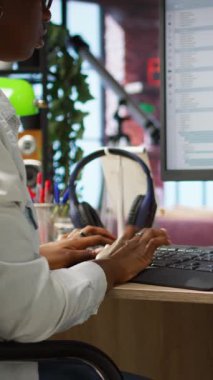 İşyeri programlamasında dikey video kodlayıcı, kod satırları yazmak, geliştirme araçları kullanmak, stres hissetmek. Ofisteki kadının son teslim tarihi var, hata ayıklama yazılımını bitirmek için stresli