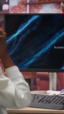 Dikey Videolu Kadın bilgisayar ekranında iş konferansını dinliyor ve izliyor, portföy belgelerindeki istatistiklere bakıyor. İş sunumuna bakan kulaklık takan kişi, kamera B
