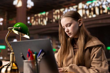 Bayan öğrenci, akademi veritabanı ve el yazısıyla yazdığı notlarla ilgili araştırmaları birleştirerek üniversite dergileri için son hazırlıklarını yapıyor. Eğitimli kız burs için savaşıyor..