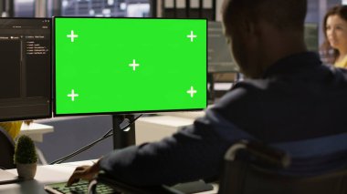 Kapsayıcı iş yerinde engelli bir adam yeşil ekran bilgisayarında makine öğrenme teknolojisiyle çalışıyor. Tekerlekli sandalyedeki belden aşağısı felçli Afrikalı Amerikalı bilişim uzmanı model bilgisayar ve kamera A verileri üzerinde çalışıyor.