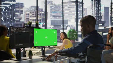 Engellilik testi yapan, programları ve sistemleri yeşil ekran PC 'ye yerleştiren kişi. Tekerlekli sandalyedeki yazılım teknisyeni. Model bilgisayardaki kodu kontrol ediyor. Ofiste oturuyor.