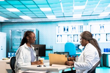 Afrika kökenli Amerikalı kadın doktor, rutin kontrol ziyareti sırasında bir kıza radyoloji sonuçlarını açıklıyor. Teşhis ve tedavi tavsiyelerine odaklanıyor. Özel bir klinikte etkili iletişim.