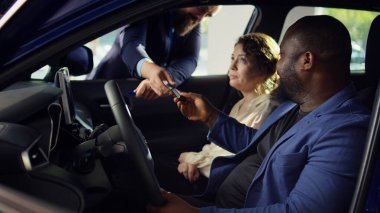 Müşteriler araba almadan önce test sürüşüne çıkıyorlar, pedallardan ve koltuk ayarlarından memnun kaldıktan sonra satıcıdan anahtar alıyorlar. Müşteriler aracın B kamerasından satın almadan önce nasıl hissettiğini değerlendirir.