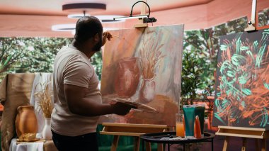 Ressam, bir tuvale belli bir teknikle suluboya boya boya uygular ve çarpıcı bir sanat eseri yaratır. Sanatçı boş zamanlarında canlı renkler ve fırça darbeleri efektleri kullanır. Kamera B.