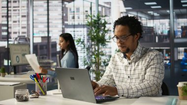 Afrika kökenli Amerikalı genel müdür iş tahminlerini ve ofis masasındaki planlarını gözden geçirir. Strateji planlaması yapar. Veri analisti şirketin amaçlarına ve kaynak tahsisine odaklanıyor. Kamera B.