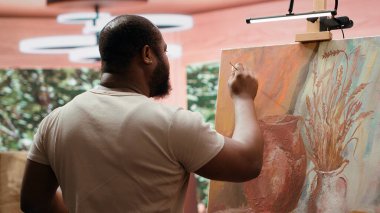 Yaratıcı bir atölyede, sanatçı mükemmel bir boya gölgesi elde etmek için pigmentleri karıştırır. Profesyonel sanat malzemelerini kullanarak tuval üzerinde güzel bir başyapıt yaratmak, atölyede kaliteli zaman geçirmek. Kamera A.