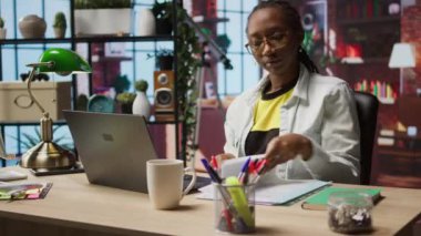 Merkez ofisteki muhasebeci dizüstü bilgisayardaki mali raporları inceliyor ve bilgi yazıyor. Dairede telgraf işçisi defterdeki belgeleri okuyor ve kağıda kalemle notlar alıyor, kamera A