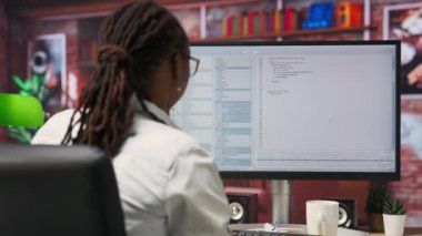Ofiste bilgisayar monitöründen UI 'ye bakarken hayal kırıklığına uğrayan mühendis programlama kodunu düzgün çalıştıramadı. IT çalışanı kodlama uygulaması, kamera B kullanırken hata gördüğünde memnun değil