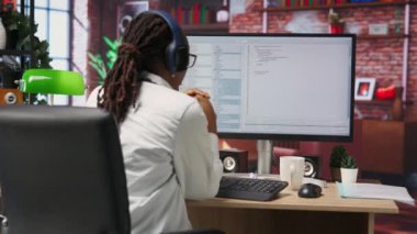 Bilgisayardaki neşeli yazılım geliştiricisi kodların derlemeyi bitirmesini bekliyor, hatasız çalıştırmayı başardıktan sonra kutluyor. Algoritma senaryoları üzerinde çalışmayı bitiren kadın mutlu, kamera B