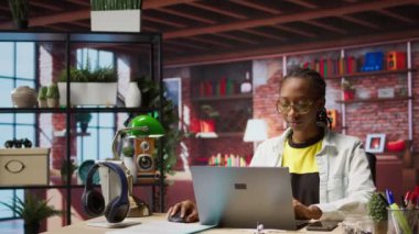 Ofisteki bilgisayarla e-posta yazan mutlu bir tele-işçi portresi. Not defterinde yazan neşeli uzaktan çalışan, bitirilmiş proje evraklarını teslim etmek için belgeler hazırlayan, kamera A