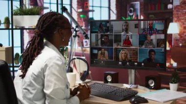 Uzaktan kumandalı ofis çalışanı çevrimiçi video görüşmesi sırasında meslektaşlarını selamlıyor, bilgisayar ekranına bakıyor. Video konferans sırasında apartman çalışanlarını karşılayan iş kadını, kamera A