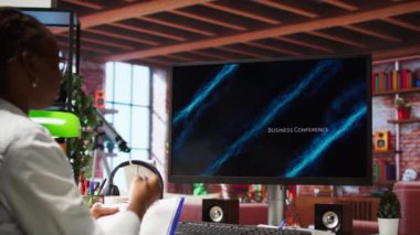 Uzaktan çalışan biri iş konferansını PC monitöründen izliyor, belgelerle ilgili istatistiklere bakıyor. Dairesinde serbest çalışan biri sunuma bakıyor ve evrak dosyalarını kontrol ediyor. Kamera A