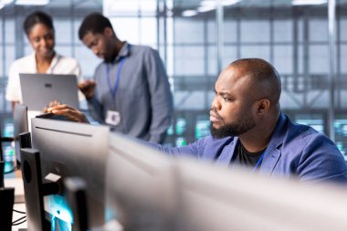 Veri merkezindeki bilgisayar bilimcileri hata kaynaklarını tespit etmek için teşhis araçları ve sistem izleme yazılımları kullanıyorlar. Bilgi işlem uzmanı sunucu odasında çalışıyor, ekipman onarıyor.