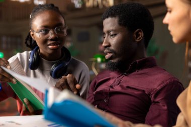 Vergiler ve kurumsal yönetim üzerine bir proje hazırlayan çok ırklı bilim adamları grubu, akademik kaynaklardan ve çevrimiçi analitik araçlardan kütüphanedeki kariyer odaklı bilgiyi artırmak için yararlanıyorlar..