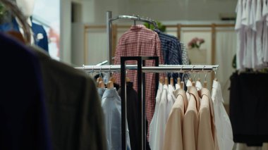 Moda rafları bir alışveriş merkezinde çeşitli şık moda ürünlerini sergiliyor, şık bir alışveriş deneyimi sunuyor ve modern moda gardıroplar için seçkin parçalar sunuyor..