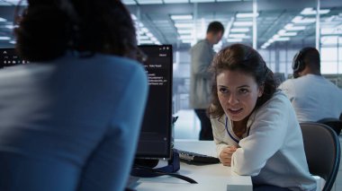 Yapay zeka sinirsel ağlarının bakımını yaparken iş arkadaşıyla sohbet eden mutlu teknisyen. Yapay zeka sistemlerini kullanırken iş arkadaşıyla konuşan neşeli yönetici, kamera B