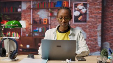 Ofisteki bilgisayarla e-posta yazan mutlu bir tele-işçi portresi. Not defterinde yazan neşeli uzaktan çalışan, bitirilmiş proje evraklarını teslim etmek için belge düzenleyen, kamera B