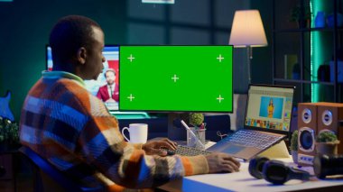 Yaratıcı bir sektörde uzaktan çalışan siyahi uzman fotoğraf editörü, imajları titizlikle düzenlemek için çift monitörlerdeki beceri ve yazılım araçlarını kullanıyor. Serbest rötuş projesi üzerinde çalışıyorum. Kamera A.