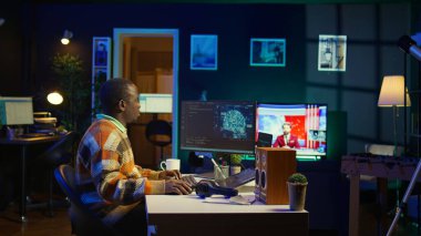 Profesyonel erkek geliştirici masadaki sinirsel ağı yönetiyor, dizüstü bilgisayarda yapay zeka kodu ile çalışıyor. Afrikalı Amerikalı bilişim uzmanı serbest çalışan siber güvenlik geliştiriyor, güvenli veri tabanı yaratıyor. Kamera B.