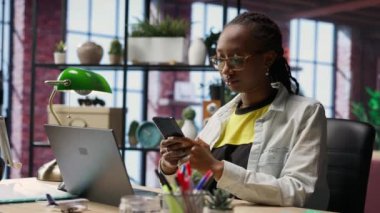 Cep telefonundan mesaj okuyan neşeli insan portresi, iyi haberler aldıktan sonra sevindi. Samimi bir dairede neşeli bir kadın akıllı telefondaki SMS ile heyecanlanıyor, arkadaşlarıyla sohbet ediyor, kamera B