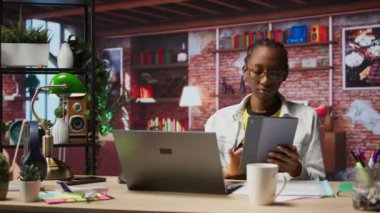 Tabletteki sosyal medyaya bakmak için işten izin alan bir kadın. Apartman ofisindeki uzaktan çalışan, sosyal ağ uygulamasını cihazda kullanmak için görevleri durduran, kamera A