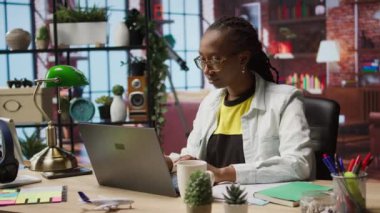 Evde e-posta yazmak için defter kullanırken tele-işçi kahve içiyor. Uzaktan kumandalı çalışan sıcak içecekten zevk alıyor ve dizüstü bilgisayar kullanıyor, son proje evraklarını teslim etmek için belgeler hazırlıyor, kamera A