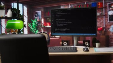 Parlak ev ofisindeki masadaki bilgisayar ekranında kodlama arayüzü gösteriliyor. Komut satırları kod düzenleyici program UI 'de modern konforlu oturma odası çalışma alanında PC ekranında yazıldı