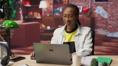 Evde kahve içen ve internette internette gezinen bir öğrenci internette bilgi araştırıyor. Okul işleri için dizüstü bilgisayardaki internet makalelerini okurken sıcak içecekten hoşlanan kadın, kamera B