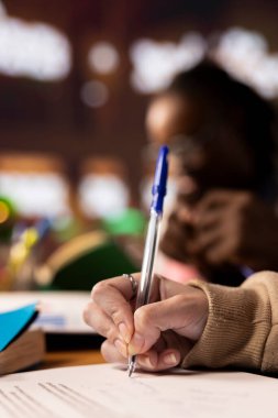 Kütüphanedeki öğrenciler, işletme yönetimi ve takım projeleri için notlar alarak üniversite veritabanına danışarak grup tartışmasına giriyorlar. Öğrenci hayatı. Kapat..