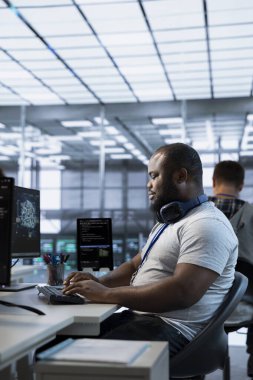 Yüksek teknoloji işyerinde çalışan gülen teknisyenler farklı iş yükleri için bilgisayar kaynakları sağlıyorlar. Veri merkezi ana bilgisayarlarını izlemekle görevli ışıl ışıl bilişim uzmanı