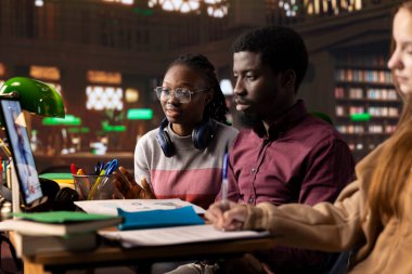 Bir kütüphanedeki üniversite öğrencileri tele sağlık dersine katılmak için online video konferansı kullanırlar, mikrobiyoloji ve tıbbi teknikleri daha sonra bir uzmanla pratik yapmak için tartışırlar. Tıp Akademisi.