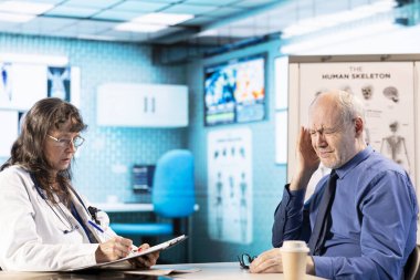 Yaşlı kadın doktor, hasta için şiddetli migreni tedavi etmek için ağrı kesiciler ve sağlık için bazı ilaveler öneriyor. Doktor emekli bir adama danışıyor, kabinede baş ağrısı çekiyor..