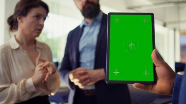 Satış elemanı yeşil ekran tablet kullanarak müşterilere araba kabul seçenekleri sunuyor, satın almaları için onları etkilemeye çalışıyor. Showroom acentesi, müşterilere uzatılmış garanti veriyor, elinde model cihazı, kamera B