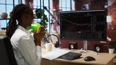 Bilgisayarı kullanan mutlu bir tüccar, iyi performans gösteren hisse senedi alıp kârla sattıktan sonra tatmin oluyor. Borsa portföyü ve kamera A 'dan para kazandıktan sonra neşeli Forex tüccarı sevindi.