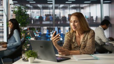 Çok uluslu bir şirketin müdürü telekonferans yapıyor, iş operasyonlarını ve stratejik planlamayı yönetiyor. Kadın, karar vermek için yatırımcı grubuyla çevrimiçi görüşüyor. Kamera B.