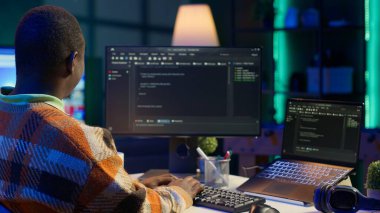 Siyah yazılım mühendisi bilgisayar ve siber güvenliğe karmaşık ikili kod senaryoları yazar. Tüketici verilerini korumak için programlama dilini kullanarak merkez ofisteki bilişim uzmanına telgraf çekmek. Kamera A.