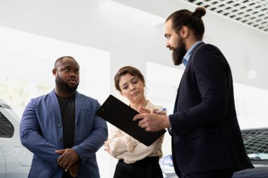 Araba galerisi satış yöneticisi müşterilerle ihtiyaçlarını tartışmak ve anlaşma tekliflerini sunmak için toplanıyor. Deneme sürüşlerine katılmak isteyen müşteriler satış temsilcisiyle sohbet ediyorlar.