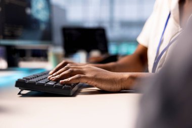 Close up of cybersecurity expert monitoring security incidents affecting server hub network. Programmer in data center typing on keyboard, protecting company critical infrastructure from cyber threats clipart