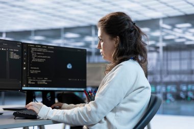 Hardworking technician working in high tech workspace providing computing resources for different workloads. Woman in office tasked with monitoring data center supercomputers clipart