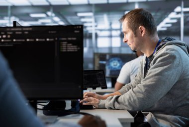 Yüksek teknoloji veri merkezi işyerindeki hataları düzeltmeye çalışırken bilgisayar hatası yapan adam görevleri çözüyor. Ana sistemlerdeki hataları düzeltmeye çalışan sunucu tarım işçisi, bilgisayar klavyesinde yazıyor