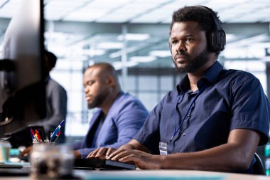 Veri merkezinde şarkı dinlemek için kulaklık takan bir adam yazılım uygulamaları için teknik belgeler hazırlıyor. IT uzmanı müzik dinliyor, sunucu odasında çalışıyor, veritabanlarını koruyor