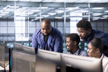 Yönetim yöneticisi veri merkezi çalışanlarını kontrol ediyor yazılım uygulamaları için teknik belgeler hazırlıyor. Sunucu odasında veri tabanlarını koruyan bilişim çalışanlarını denetleyen takım lideri