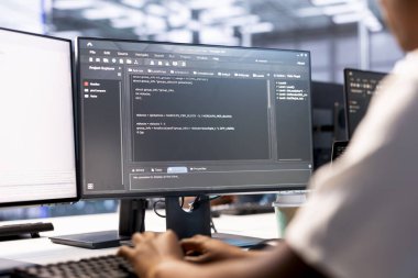 Veri merkezinin çalışma alanındaki geliştirici hata kaynaklarını belirlemek için sistem izleme yazılımı ve teşhis araçları kullanıyor. Sunucu çiftliğinde çalışan bir kadın, ekipman onarıyor.