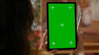 Ressam, resim atölyesinde, yağlı boya resimli bir başyapıta bakan, izole edilmiş bir maket ekranlı bir cihaz tutuyor. Güzel bir sanat galerisi için güzel bir kırsal sanat eseri, yaratıcılık. Kamera A.