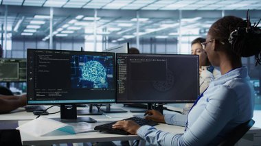 Makine öğrenme eğitimi için kullanılan yapay zeka veri merkezindeki programlama görevlerini bitirdikten sonra masadan ayrılan kadın. Yapay zeka teknolojisini güncelledikten sonra mühendis vardiyasını bitirdi. Kamera B, kapat.