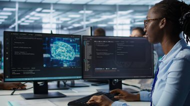 Yapay zeka veri merkezindeki kadın programlama, makine öğrenme eğitimi için kullanılan gelişmiş ekipmanlara ev sahipliği yapıyor. Yapay zeka teknolojisini geliştirmek için çalışan Afrikalı Amerikalı yönetici. B kamerasını kapat.
