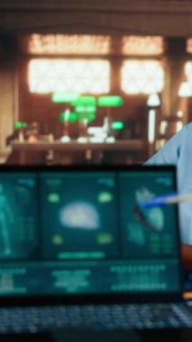 Dikey Video Siyahi Tıp Fakültesi öğrencileri online bilgi kullanarak çalışıyor ve not alıyor, kütüphanedeki bir tez projesini inceliyor. Genç adam tıbbi araştırma için akademik veri topluyor. Kamera B.